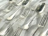 a lot of forks and spoons wrapped in plastic