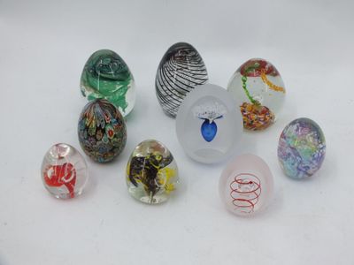 de nombreuses billes de verre de différentes couleurs sur une surface blanche