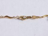 a close up of a gold chain bracelet with a heart charm