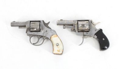two old revolvers are sitting side by side on a white surface