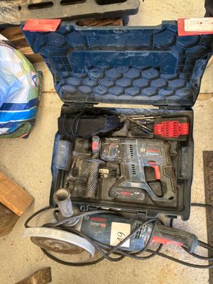 une trousse à outils posée par terre à côté d'autres outils