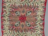 a red square scarf with a floral design on it