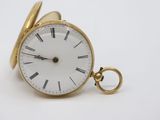 a gold pocket watch with roman numerals on it