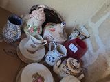 une boîte remplie de tasses à thé et de soucoupes posée par terre