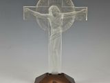 une image représentant un crucifix en verre transparent posé sur un socle en bois