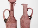 three pink glass vases sitting next to each other on a white surface
