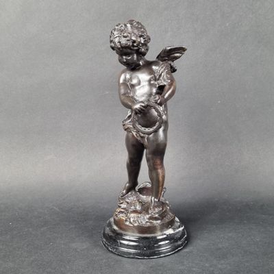 statue of a boy holding a bird on a pedestal