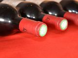several bottles of wine are lined up on a red table