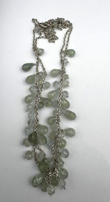 un gros plan d'un collier composé de perles vertes sur un fond blanc