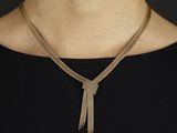 une femme portant un collier en or et un haut noir