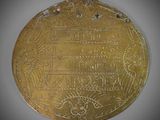an old gold medal with a design on it