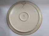 a white plate with a bird on it on a table