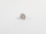 un gros plan d'une bague sertie d'un seul diamant posée sur une surface blanche
