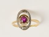 un gros plan d'une bague en or ornée d'une pierre rose au centre