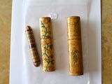 trois tubes en bois posés sur une feuille de papier, elle-même posée sur une table