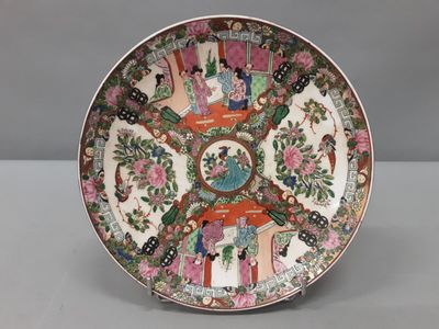 une image représentant une assiette ornée d'un motif représentant des personnes et des fleurs
