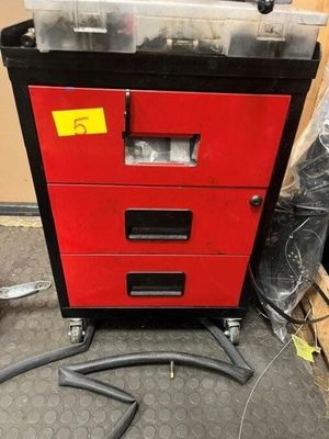 a red tool cabinet with a black drawer and a hose