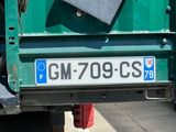 a green truck with a box on the back of it