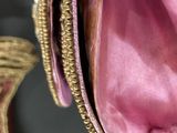 a person holding a pink purse with a gold zipper