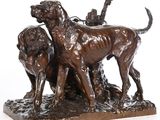 statue en bronze représentant deux chiens et un oiseau posés sur un rocher