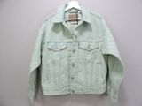 denim jacket hanging on a hanger on a white wall