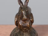 a bronze statue of a rabbit sitting on a table