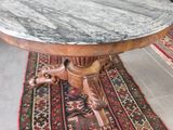 une table au plateau en marbre posée sur un tapis au sol