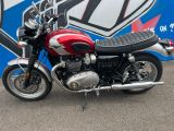 a red and black motorcycle parked in front of a blue and white wall