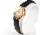 an image of a gold watch on a white display stand