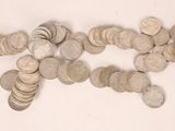 a pile of silver coins on a white surface
