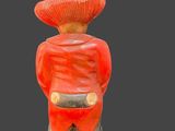 statue of a man in a red jacket and hat with his hands in his pockets