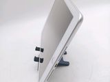 a tablet computer sitting on a stand on a white surface