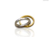 two gold and silver wedding rings on a white surface