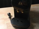 a black coffee maker sitting on a wooden table