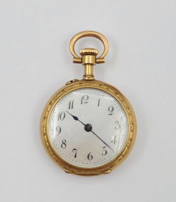 une montre de poche en or sur une surface blanche