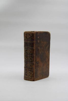 an old book sitting on top of a white surface