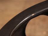 a close up of a black chair with a small bug on it