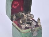 a small green box with a silver ring inside of it
