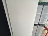 a white refrigerator sitting in a kitchen next to a red chair