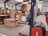 a forklift in a warehouse with many boxes on the floor