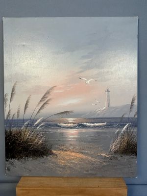 un tableau représentant un phare sur la plage, avec des mouettes en arrière-plan
