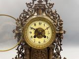 a gold clock with a magnifying glass in front of it