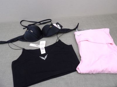 a black bra top and a pink bra top on a bed