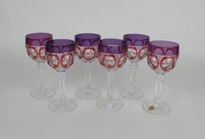 quatre verres à vin violets ornés de cœurs, posés sur une table