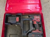 a red tool box filled with tools sitting on top of a cement floor