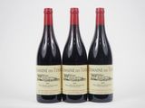 trois bouteilles de vin rouge posées l'une à côté de l'autre sur une surface blanche