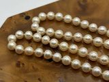 pearl necklace on a wooden board on a white background