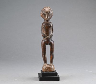 une statue en bois d'un homme avec un chapeau sur la tête