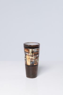 un verre à shot marron et blanc posé sur une table blanche