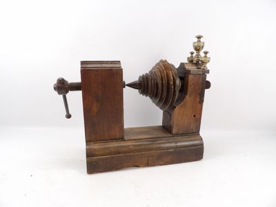 une machine à l'ancienne, avec un socle en bois posé sur une surface blanche